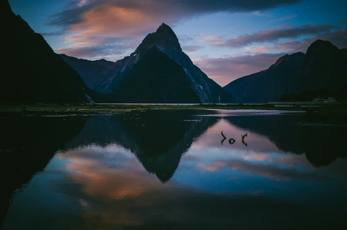 Mountains reflected in the still water of Milford Sound