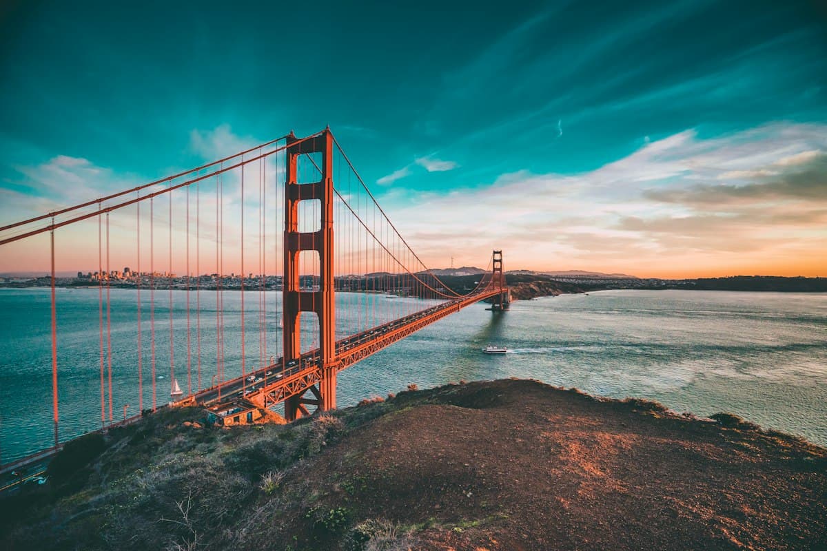 The Golden Gate Bridge at sunset, seen from the hills above it