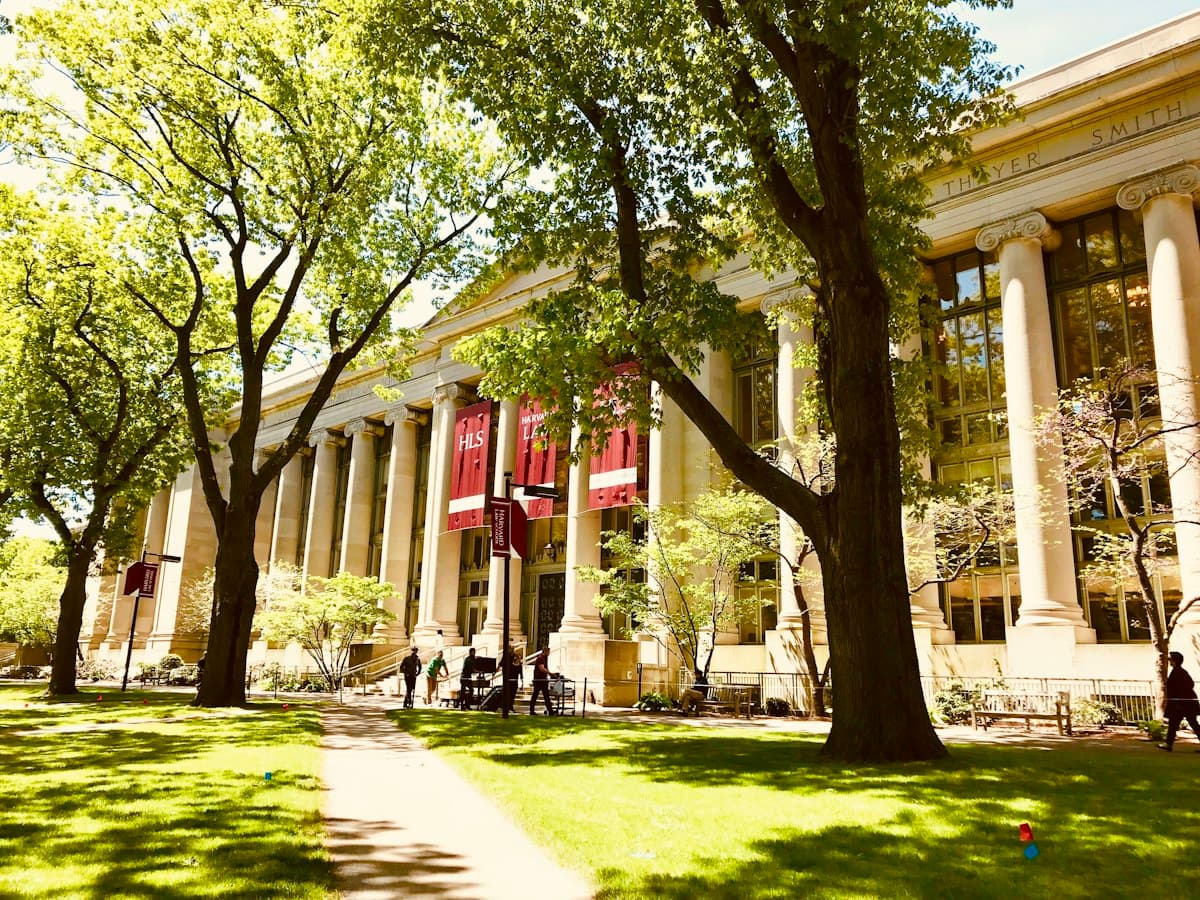 A columned building behind trees and a lawn at Harvard Law School